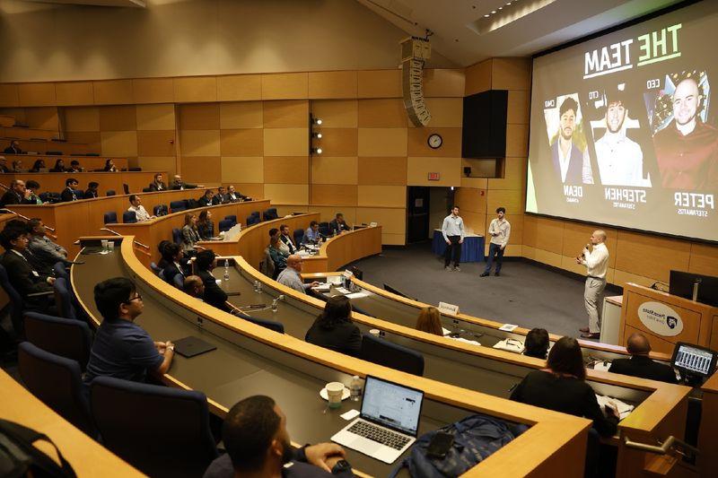 people speaking in front of a crowd